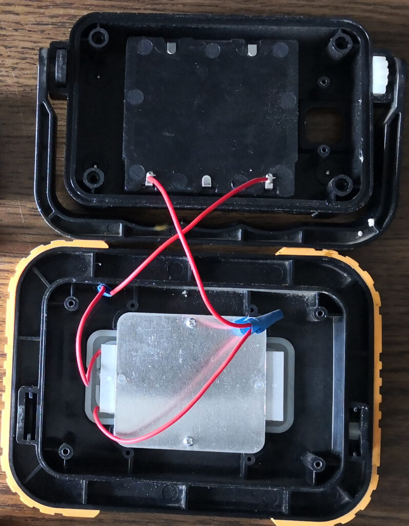 Spotlight opened. Two pairs of wires connected and insulating tape wrapped around.